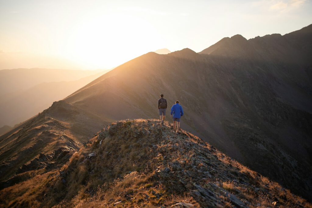 Two people standing on a mountain top at sunset – resolving conflicts in a concentrated format