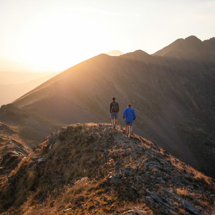 Two people standing on a mountain top at sunset – resolving conflicts in a concentrated format