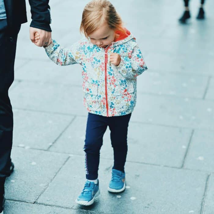 A child holding a parent’s hand on the way – co-parenting after separation